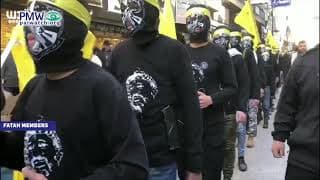 Masked Fatah members wear mock suicide belts at Fatah rally