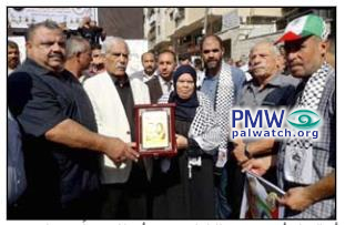 Fatah in Gaza honors mother of terrorist who beat an Israeli to death with a shovel